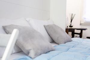 a white bed with blue sheets and pillows at Housmart Tovaglie 9 int 7 in Bologna