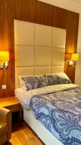 1 dormitorio con 1 cama con cabecero grande en Sloane Square Apartments en Londres