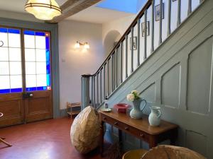 Cette chambre dispose d'un escalier et d'une table fleurie. dans l'établissement Frizenham Farmhouse, à Little Torrington