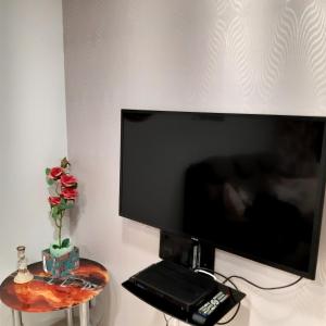 telewizor z płaskim ekranem siedzący na ścianie z telefonem w obiekcie Apartament Hetmańska w Wałbrzychu