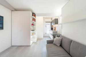 a living room with a couch and a kitchen at Housmart Tovaglie 9 int 7 in Bologna