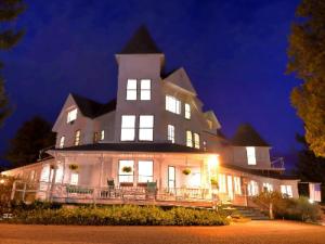 a large white house with a tower at night at Anne's Washington Inn in Saratoga Springs