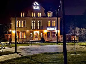 a building with a sign on top of it at night at Stylowa Kolbuszowa in Kolbuszowa
