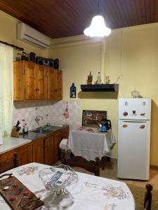 cocina con nevera blanca y mesa en Villa Lochia - Καλημέρι, en Elafopídima