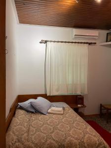 1 dormitorio con cama y ventana en Villa Lochia - Καλημέρι, en Elafopídima