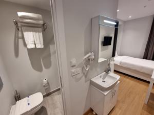 y baño con aseo, lavabo y espejo. en 10m2 Hotel, en Estambul