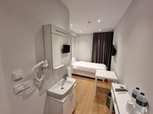 baño blanco con lavabo y cama en 10m2 Hotel en Estambul