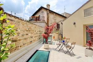 patio con piscina accanto a un muro di mattoni di Guest House Viaroma a San Severino Marche