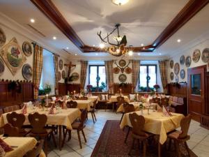 ein Restaurant mit Tischen, Stühlen und einem Kronleuchter in der Unterkunft Hotel-Gasthof Sperrer in Grassau