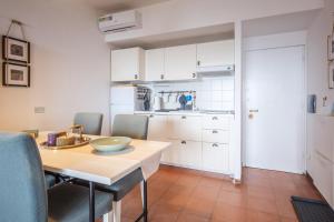 uma cozinha e sala de jantar com mesa e cadeiras em LA BRIOSA-INFINITYHOLIDAYS em Costa Paradiso
