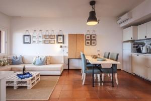 uma sala de estar com um sofá e uma mesa com cadeiras em LA BRIOSA-INFINITYHOLIDAYS em Costa Paradiso