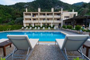 un hotel con una piscina con sillas y un edificio en Casa Laios en Chiliadou