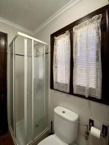 Un baño con inodoro y ducha de cristal. en Gran Casa Rural La Vendimia, en Los Arenales de la Moscarda 32 fotos más