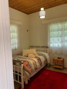ein Schlafzimmer mit einem Bett in einem Zimmer mit Fenstern in der Unterkunft Villa Lochia in Rámia