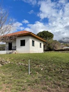 a white house with a grass field in front of it at Villa Lochia in Rámia