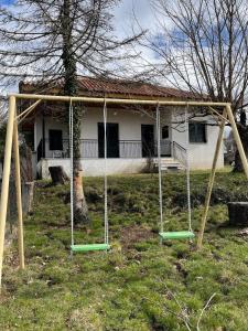 un columpio en un patio frente a una casa en Villa Lochia, en Rámia