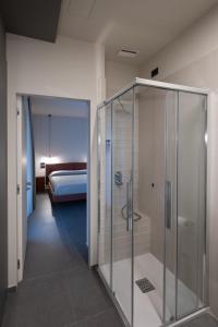 a glass shower in a room with a bedroom at BBCUBE in Porto Viro