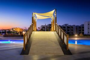 uma ponte de madeira sobre uma piscina à noite em Matarma Beach Residence em Ras Sedr