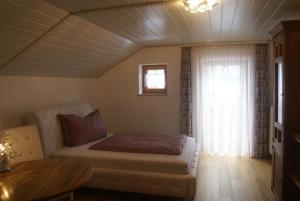 a bedroom with a bed and a table and a window at Ferienhaus Füchslein in Bayerisch Gmain