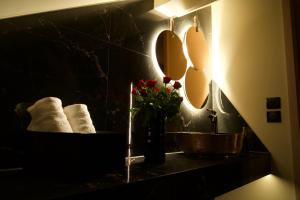 un baño con lavabo, espejos y un jarrón con flores en Magnifique Villa le89golden jacuzzi et sauna privatif, en Mulhouse