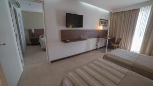 
a hotel room with a bed and a tv at Hotel Estilo MB - Villa Carlos Paz in Villa Carlos Paz
