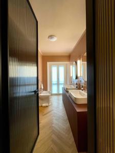 ein Badezimmer mit zwei Waschbecken, einem WC und einem Spiegel in der Unterkunft Cà Bèla - Moscova in Mailand