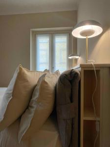 ein Schlafzimmer mit einem Bett mit Kissen und einem Fenster in der Unterkunft Cà Bèla - Moscova in Mailand