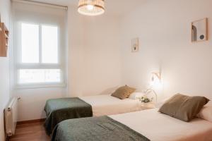 バレンシアにあるApartamentos FV Flats Valencia - San Felipe Neriのベッド2台と窓のある寝室