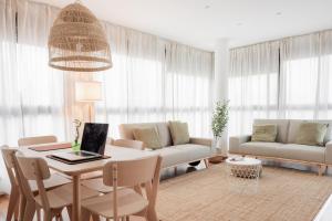 a living room with a table with a laptop on it at Apartamentos FV Flats Valencia - San Felipe Neri in Valencia