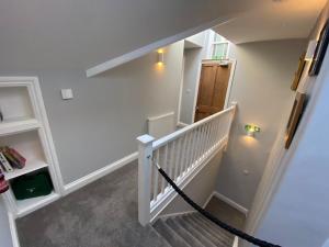 a hallway with a stairway leading up to a room at East Llanteg Guest House in Amroth