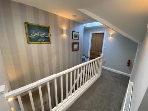 a hallway with stairs with a painting on the wall at East Llanteg Guest House in Amroth
