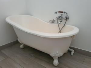 a white bath tub sitting in a bathroom at Plett57 - Self Catering - Room No2 in Plettenberg Bay