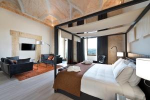a bedroom with a large bed and a living room at Áurea Convento Capuchinos by Eurostars Hotel Company in Segovia