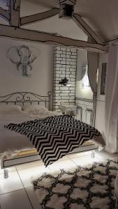 una camera da letto con un piumone bianco e nero su un letto di Studio illustré Insolite a Sablé-sur-Sarthe