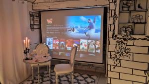 a room with two chairs and a projection screen at Studio illustré Insolite in Sablé-sur-Sarthe