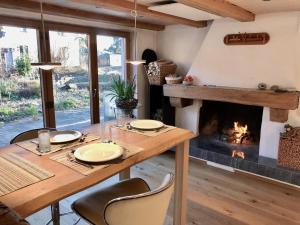 a dining room with a table and a fireplace at Ferienhaus mit Naturgarten in Dachsen