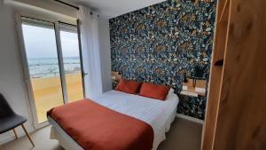 a bedroom with a large bed and a large window at Au Bon Accueil in Perros-Guirec