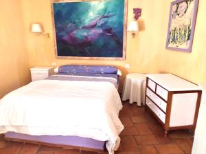 トメリョソにあるChalet rural en La Mancha con jardin y piscina privadosのベッドルーム1室(ベッド2台付)が備わります。壁には絵画が飾られています。