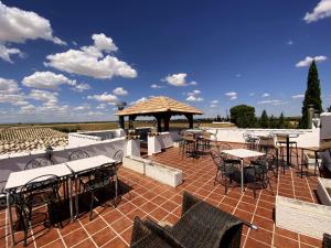 un patio con mesas y sillas y un cenador en Gran Casa Rural La Vendimia, en Los Arenales de la Moscarda