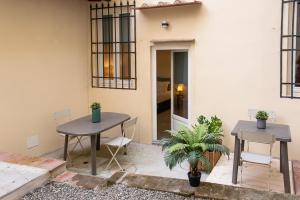 a patio with two tables and chairs in front of a building at Coco Places Apartments Santa Maria Novella, Centro Storico in Florence