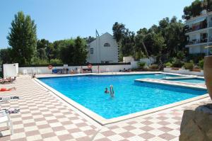 ein großer Pool mit einer Person im Wasser in der Unterkunft 501 - Ap. Cant del Ocells in Palafrugell