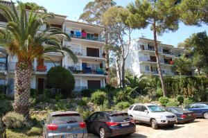 ein Parkplatz mit vor einem Gebäude geparkten Autos in der Unterkunft 501 - Ap. Cant del Ocells in Palafrugell