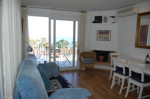 ein Wohnzimmer mit einem blauen Sofa und einem Tisch mit Stühlen in der Unterkunft 501 - Ap. Cant del Ocells in Palafrugell