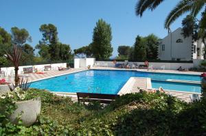 einem großen Pool mit Stühlen und Bäumen und einem Gebäude in der Unterkunft 501 - Ap. Cant del Ocells in Palafrugell