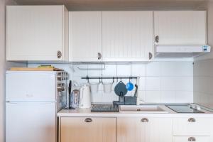 uma cozinha com armários brancos e um frigorífico branco em LA BRIOSA-INFINITYHOLIDAYS em Costa Paradiso