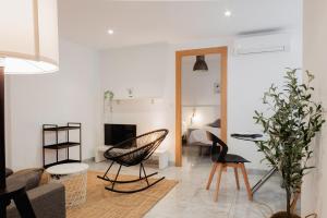Apartamentos FV Flats Valencia - Mestalla 5 في فالنسيا: غرفة معيشة مع أريكة وطاولة وكراسي
