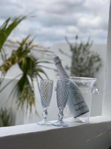 Una botella de champán y dos copas en una cornisa. en Casa Dolly Boutique B&B, en Cantoria