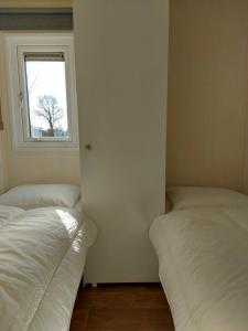 Postel nebo postele na pokoji v ubytování Stacaravan 161 5* camping De kuilart in Friesland