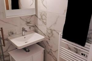 a white bathroom with a sink and a mirror at Elegant Studio fully furnished apartment! @Zürich 4 in Zurich