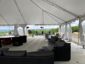 a white tent with couches and tables and chairs at Naturluxe & Stars in Watkins Glen